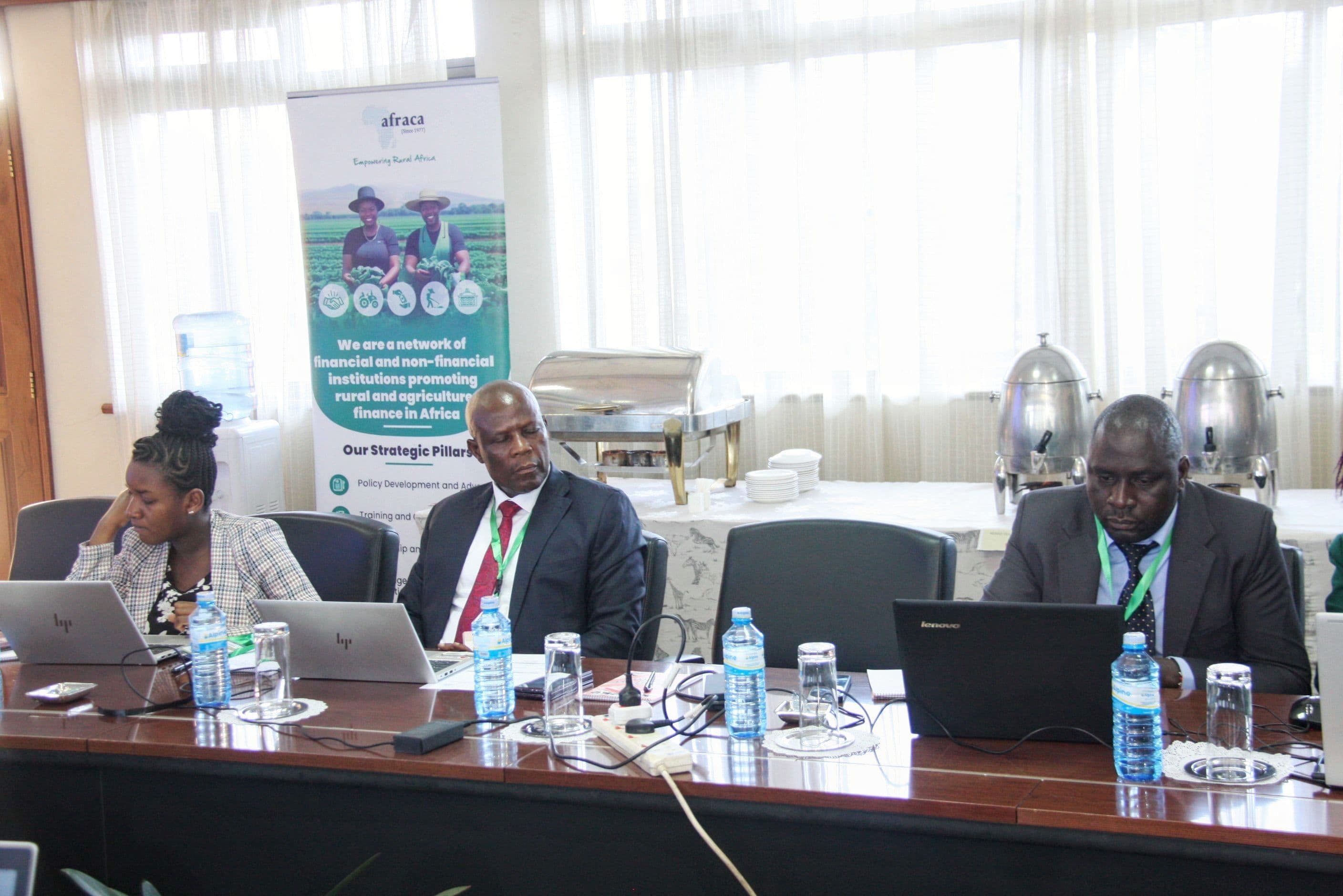 Participants seated at a table with an AFRACA banner in the background.